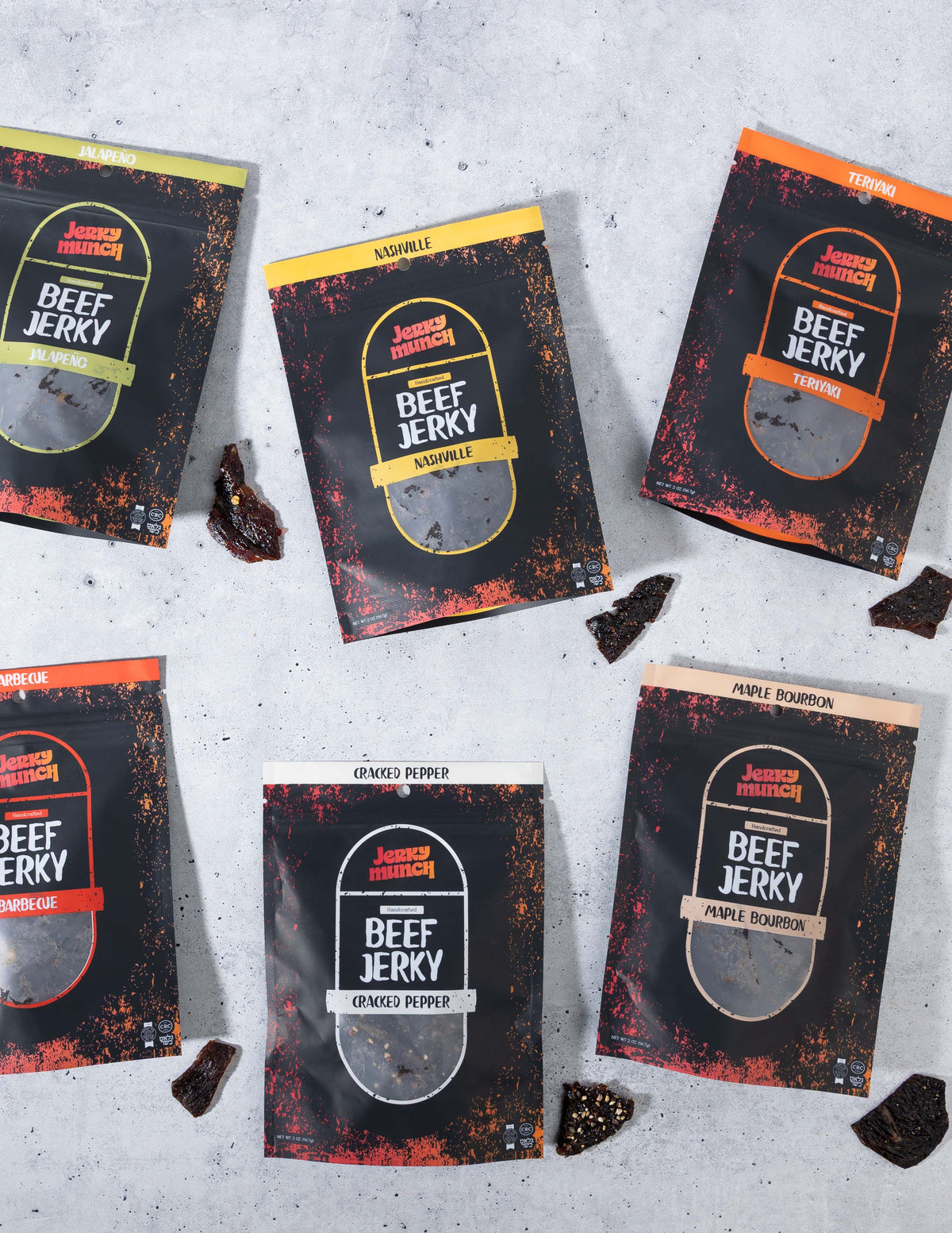 Bags of Jerky Munch kosher beef jerky in several flavors laid out on a grey table